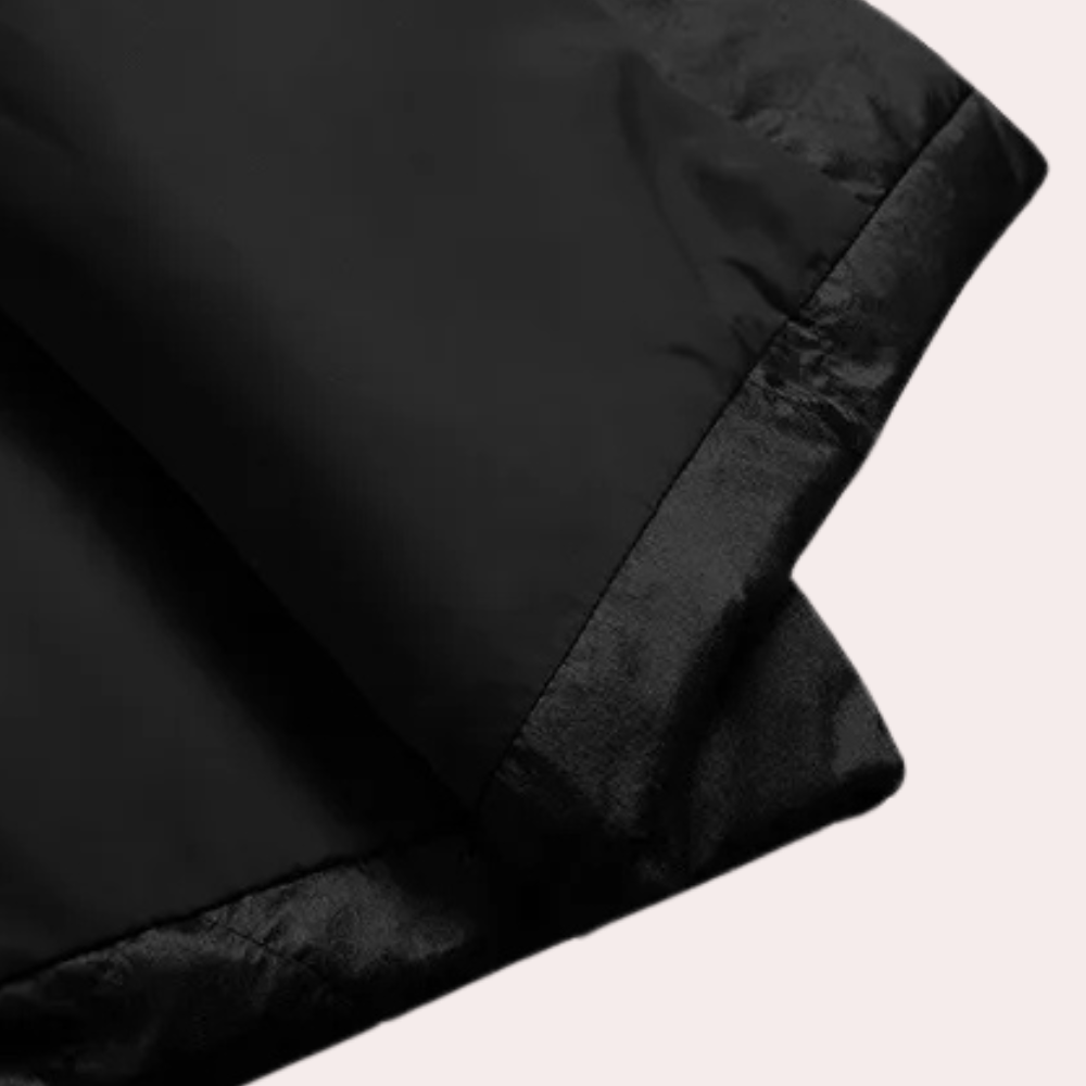 Zwarte gewatteerde jas, close-up van de zoom, modieuze winterkleding, hoogwaardige stof, warme jas voor heren en dames, stijlvol en duurzaam.