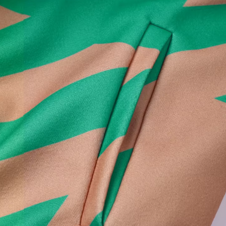 Groen en beige gestreepte satijnen stof met een subtiele glans, close-up van een naad. Luxe textiel, modeontwerp, hoogwaardige materialen.