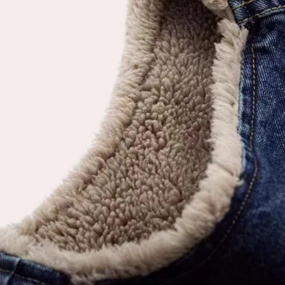 Close-up van een blauwe spijkerjas met warme, beige sherpa voering. Perfect voor wintermode, casual stijl, comfortabele kleding.