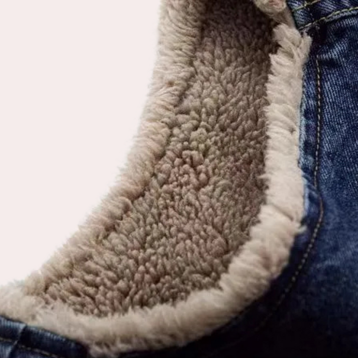 Close-up van een blauwe spijkerjas met warme, beige sherpa voering. Perfect voor wintermode, casual stijl, comfortabele kleding.
