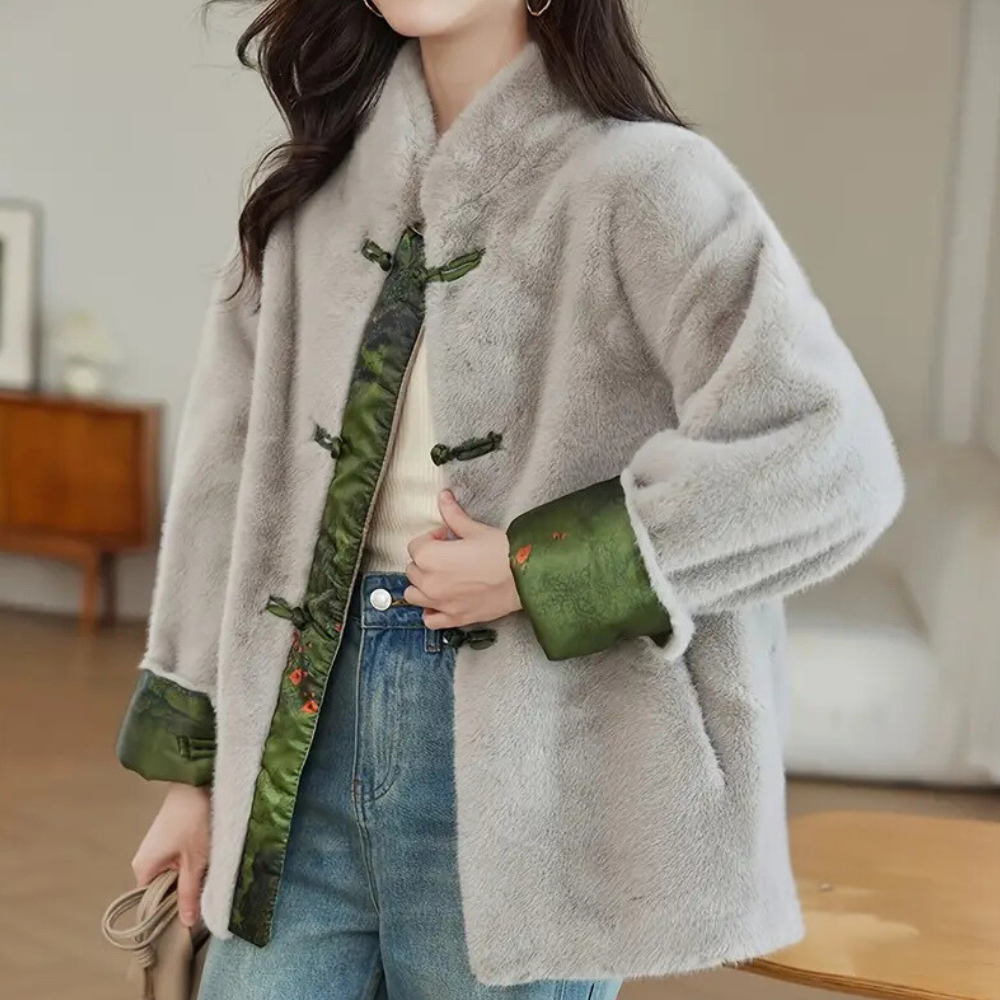 Grijze faux bontjas met groene Chinese knopen en geborduurde details, gedragen door vrouw in casual outfit. Stijlvolle wintermode, trendy dameskleding.