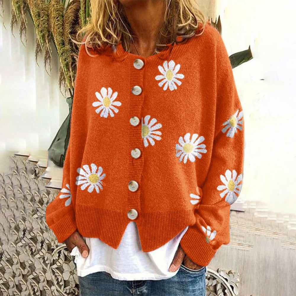Oranje damesvest met knopen en madeliefjespatroon, warm gebreid, casual stijl, ideaal voor herfstmode. Comfortabel en trendy kledingstuk.