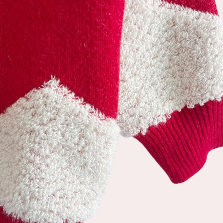 Rode en witte gebreide trui met textuur, close-up van mouw. Modieuze winterkleding, warme wollen stof, trendy design voor koude seizoenen.