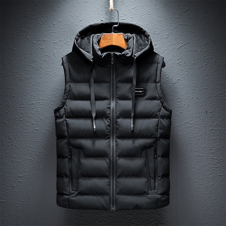 Zwarte gewatteerde bodywarmer met capuchon voor heren, ritssluiting en zakken. Stijlvolle en warme herenmouwloze jas voor wintermode.