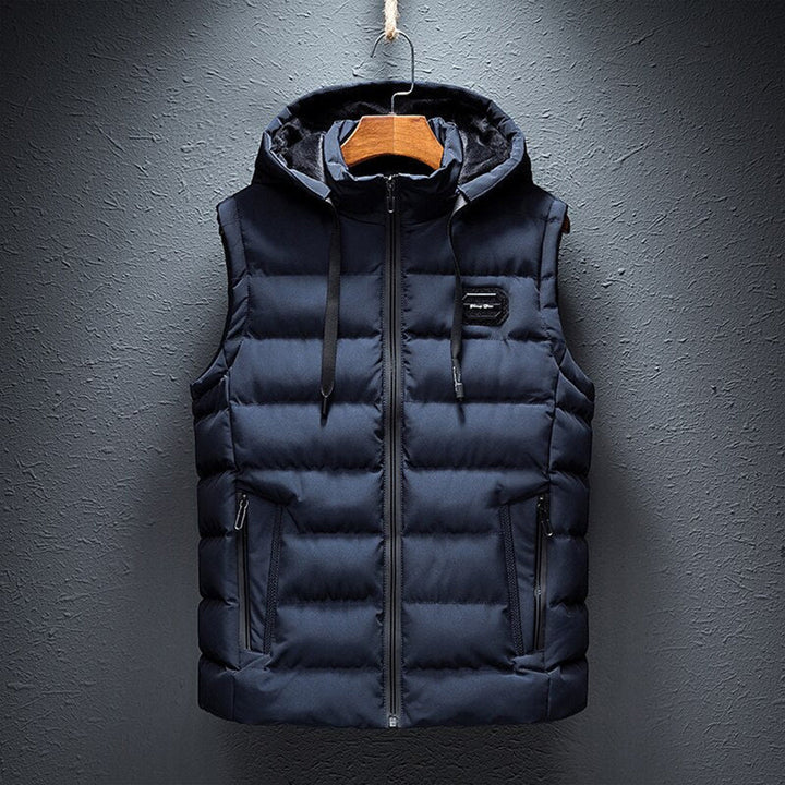 Donkerblauwe heren bodywarmer met capuchon, gewatteerd ontwerp, ritssluiting en zakken. Stijlvolle en warme winterkleding voor heren.