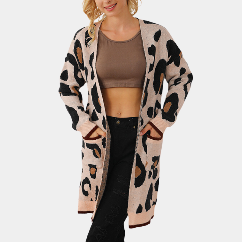 Vrouw draagt lange, beige luipaardprint cardigan met bruine en zwarte accenten, gecombineerd met een bruine crop top en zwarte jeans.