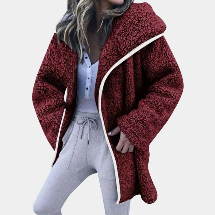 Vrouw in rode teddyjas met capuchon, witte knopenblouse en grijze joggingbroek. Wintermode, comfortabele dameskleding, trendy outfit.