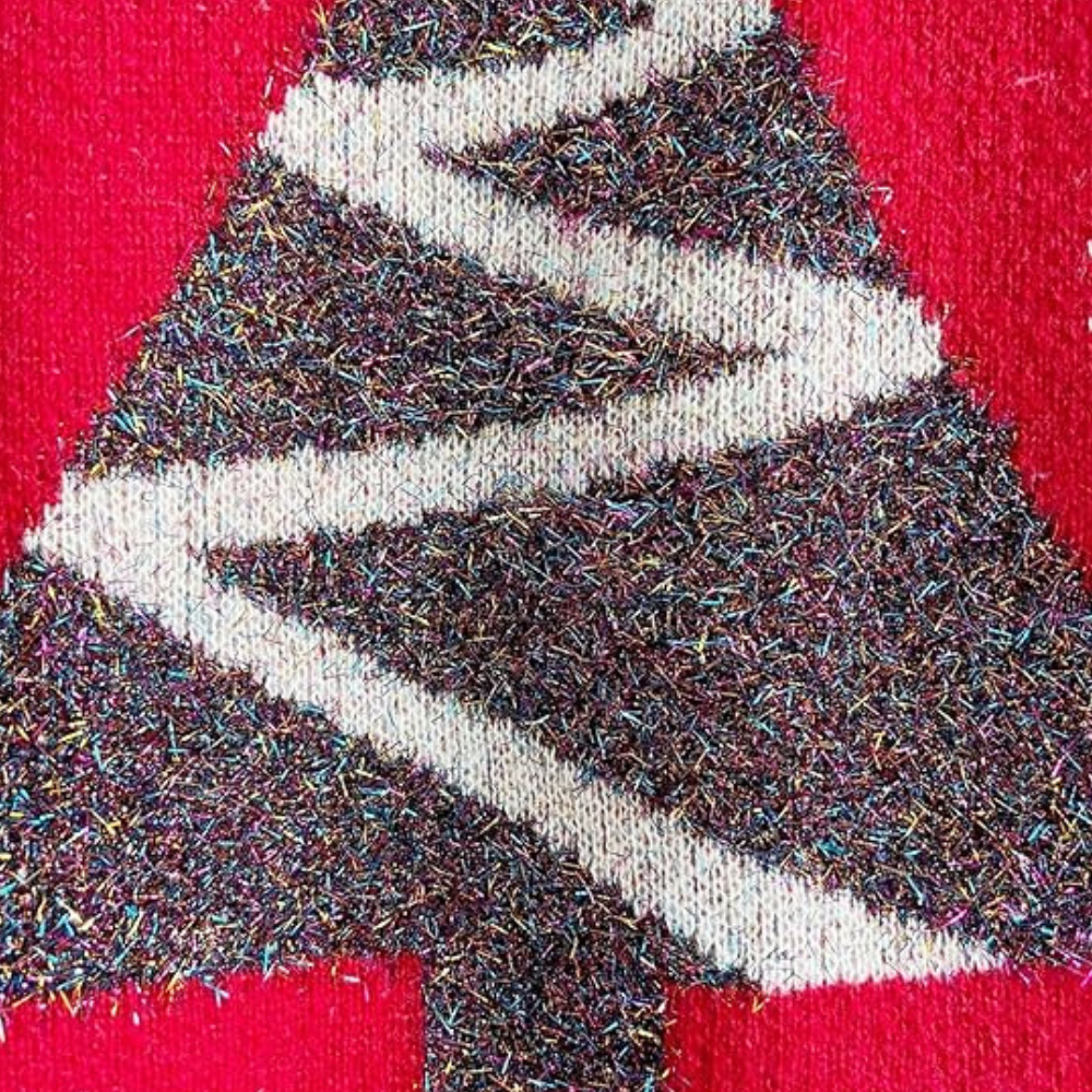 Kersttrui met glitter kerstboom op rode achtergrond, feestelijke kleding, wintermode, kerstdecoratie, kleurrijke pailletten, textuur.