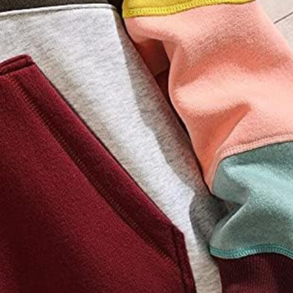 Kleurrijke hoodie met contrasterende mouwen in bordeaux, roze en groen. Comfortabele katoenen stof, ideaal voor casual mode en streetwear.