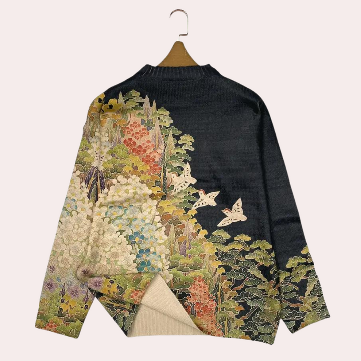 Vintage kimono-stijl trui met kleurrijk bloemen- en vlinderpatroon op zwarte achtergrond, hangend aan houten hanger. Uniek Japans design.