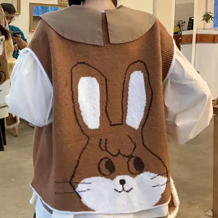 Bruine trui met groot konijnmotief op de rug, gedragen door persoon in café. Trendy mode, casual kleding, konijnendessin, herfststijl.