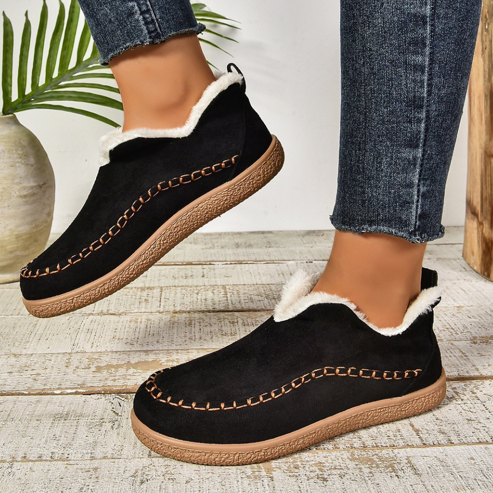 Zwarte dames winterschoenen met witte voering, comfortabele suède look, bruine stiksels en rubberen zool, perfect voor koude dagen.