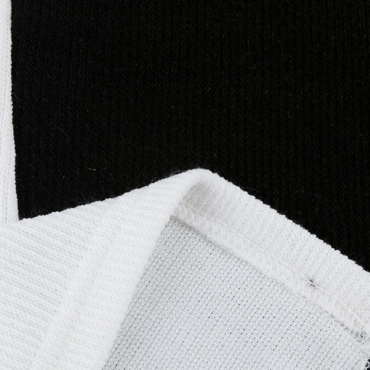 Zwart-witte katoenen stof close-up, textuur en stiksel zichtbaar. Ideaal voor modeontwerp, kledingproductie, hoogwaardige textielmaterialen.