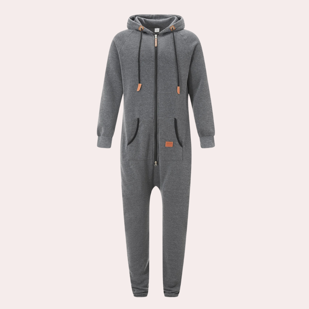 Grijze unisex onesie met capuchon, ritssluiting en zakken. Comfortabele loungewear, ideaal voor thuis of casual gebruik. Perfect voor alle seizoenen.