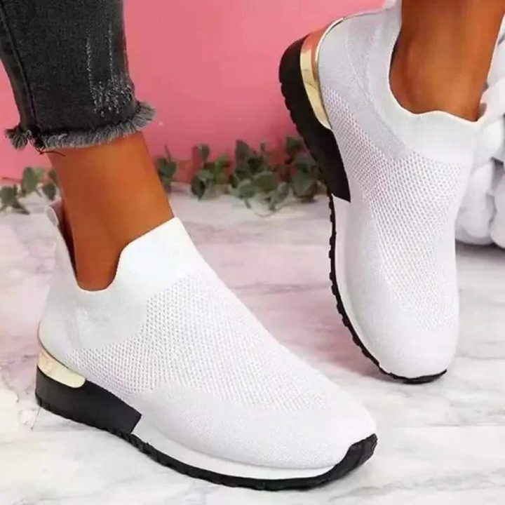 Witte slip-on damesschoenen met ademend mesh, comfortabele zool en moderne stijl, ideaal voor casual en sportieve outfits.