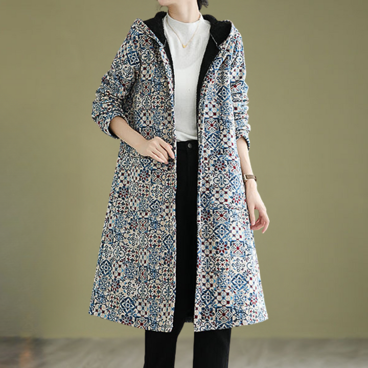 Vrouw draagt lange, kleurrijke, gebloemde jas met capuchon; modieuze winterkleding, casual stijl, comfortabele pasvorm, trendy damesmode.