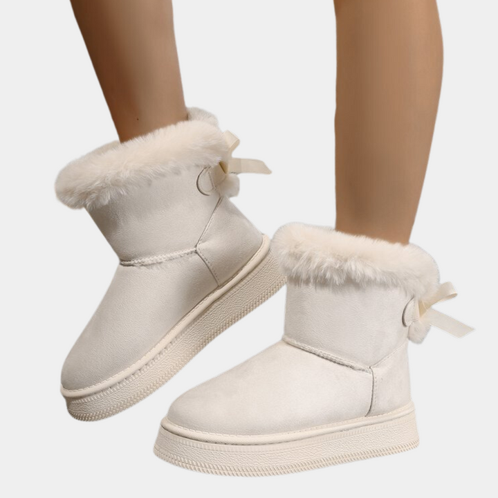 Witte dameslaarzen met bontvoering en strikdetail, wintermode, warme en comfortabele schoenen, trendy en stijlvol voor koude seizoenen.