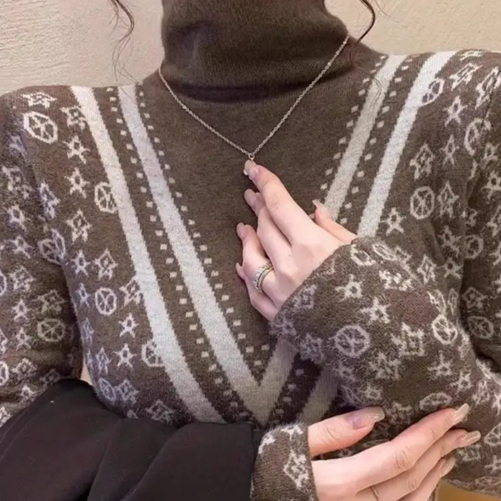 Bruine coltrui met geometrisch patroon en ketting. Modieuze dameskleding, herfst- en winterstijl, comfortabele en stijlvolle trui.