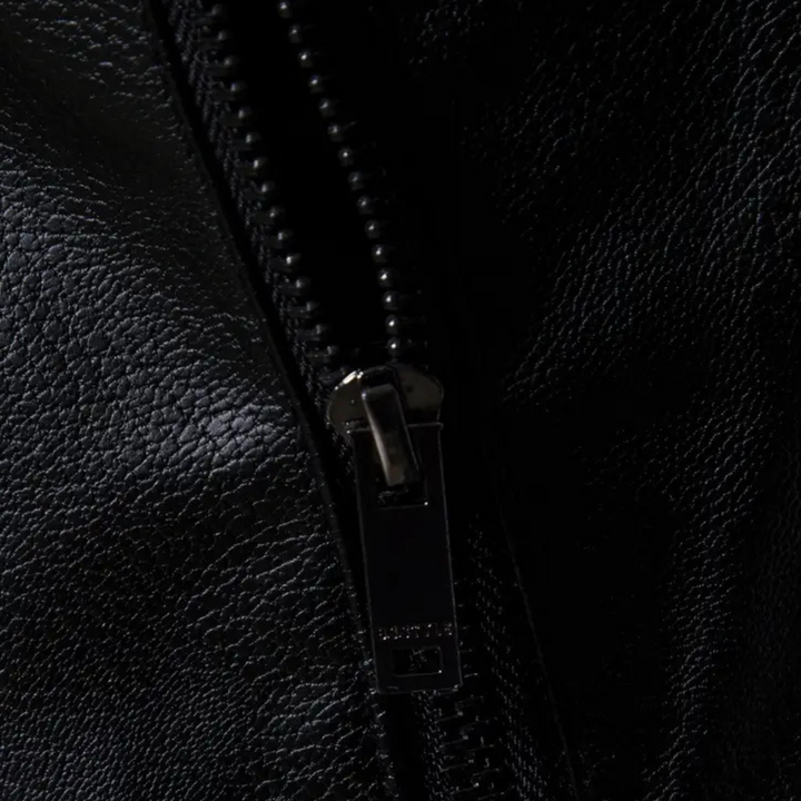 Zwarte leren jas met metalen ritssluiting, close-up. Hoogwaardige textuur, modieuze kleding, duurzame rits. Perfect voor herfst- en wintermode.