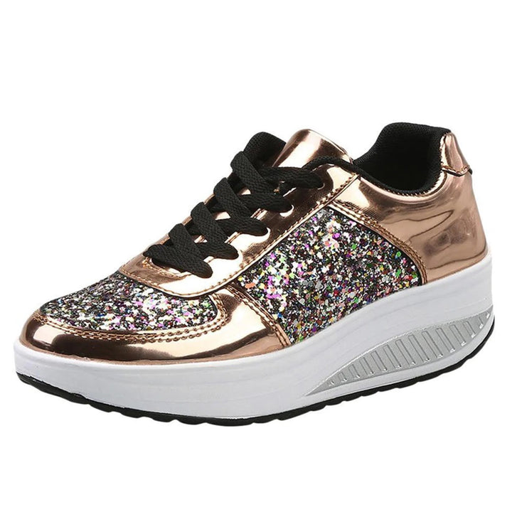 Gouden damessneaker met glitters, zwarte veters en witte platformzool. Modieuze sportschoen, ideaal voor casual en trendy outfits.