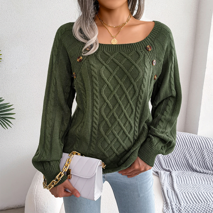 Vrouw in groene kabeltrui met knopen, draagt een witte schoudertas en lichte spijkerbroek. Stijlvolle herfstmode, casual outfit.