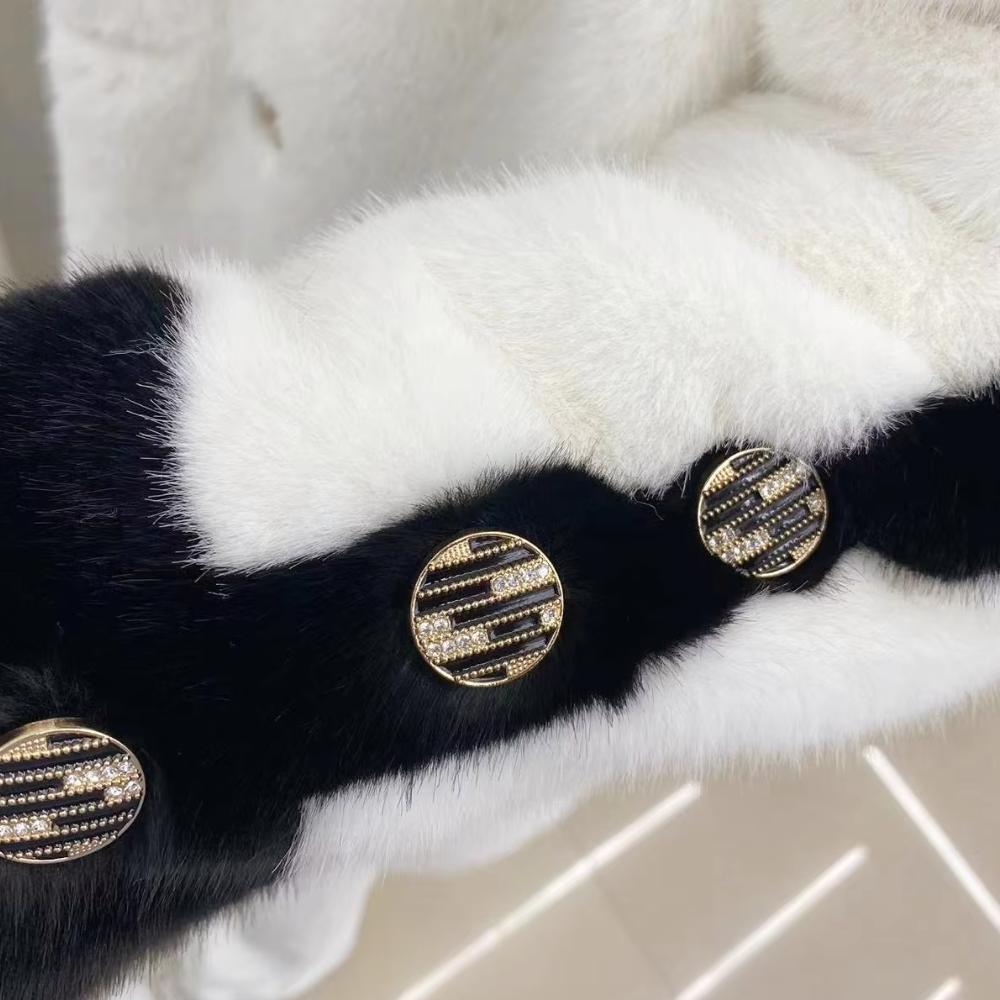 Witte en zwarte bontjas met gouden knopen, luxe damesmode, winterkleding, stijlvolle en elegante uitstraling, hoogwaardige materialen.