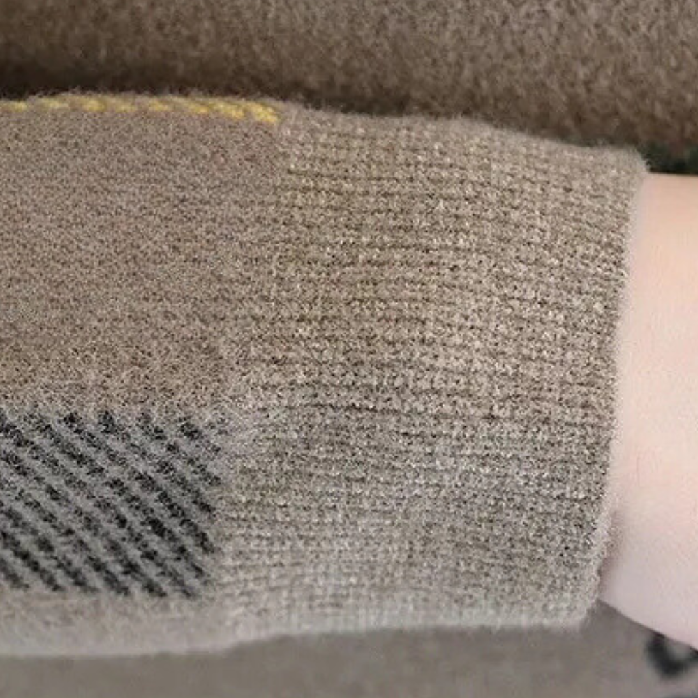Beige wollen trui met geruite elleboogpatch, close-up. Zachte textuur, modieuze herenkleding, herfst-winter stijl, comfortabele outfit.