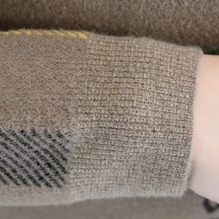 Beige wollen trui met geruite elleboogpatch, close-up. Zachte textuur, modieuze herenkleding, herfst-winter stijl, comfortabele outfit.