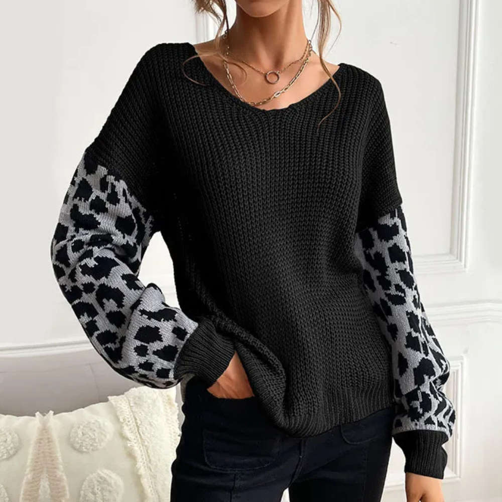 Vrouw draagt zwarte gebreide trui met luipaardprint mouwen, casual mode, herfstkleding, trendy dameskleding, comfortabele outfit.