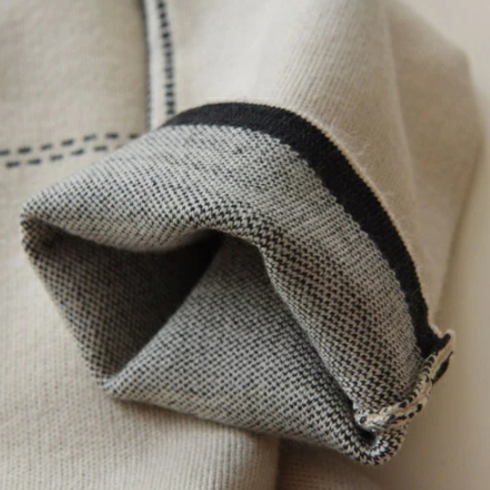 Beige en grijze wollen sjaal met zwarte rand, close-up. Hoogwaardige wol, warme winteraccessoire, stijlvol en comfortabel.
