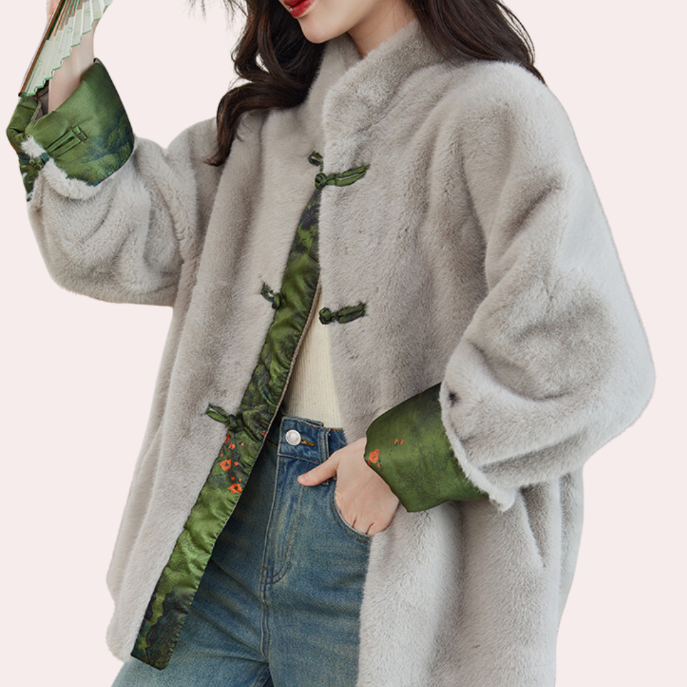 Grijze bontjas met groene zijden voering en traditionele knopen, gedragen door model in casual outfit. Luxe wintermode, stijlvolle dameskleding.