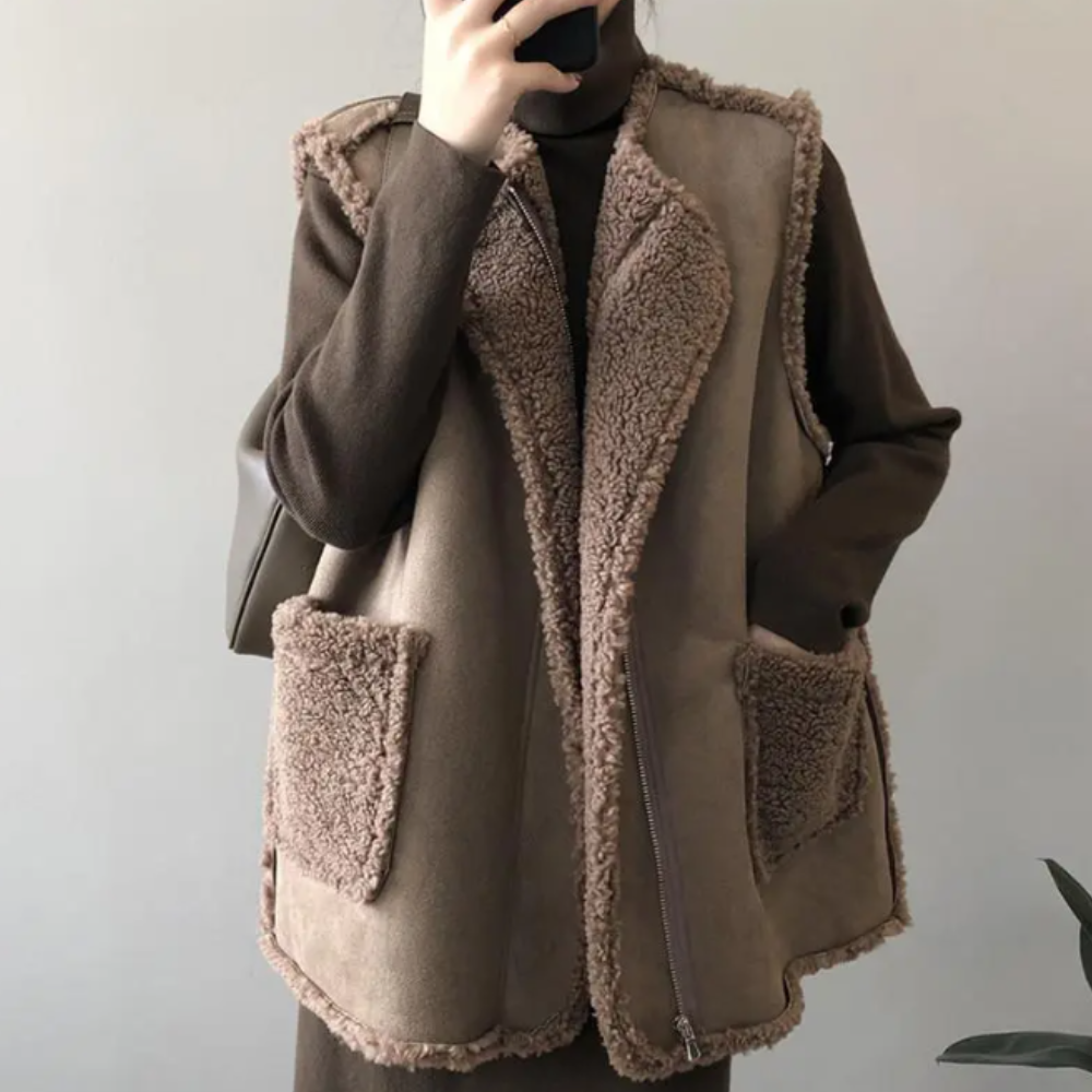 Vrouw draagt bruine schapenvacht gilet met zakken, perfect voor herfstmode. Stijlvolle, warme outfit voor dames. Trendy en comfortabel.