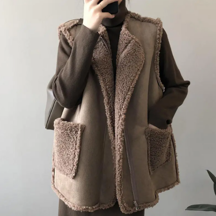 Vrouw draagt bruine schapenvacht gilet met zakken, perfect voor herfstmode. Stijlvolle, warme outfit voor dames. Trendy en comfortabel.