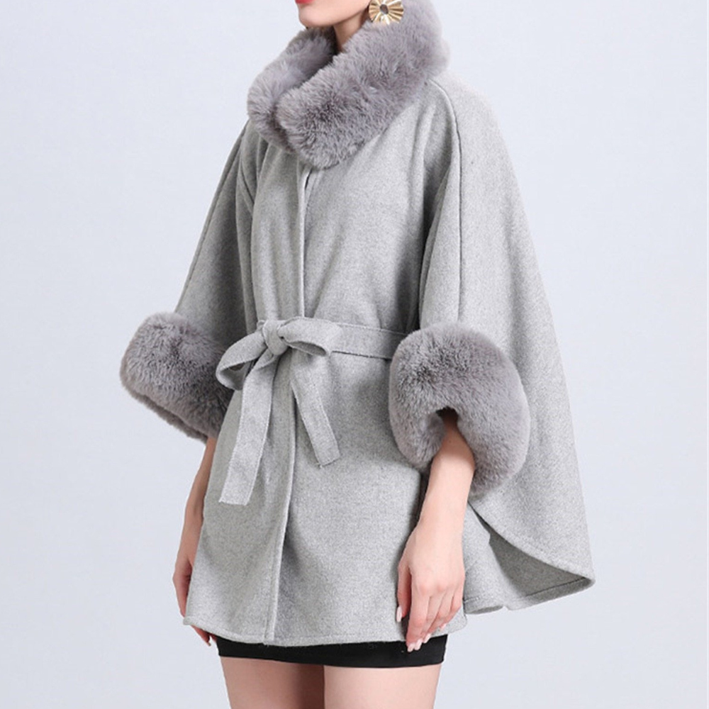 Grijze damescape met kunstbontkraag en manchetten, tailleceintuur, elegante wintermode, stijlvolle warme jas, modieuze dameskleding.