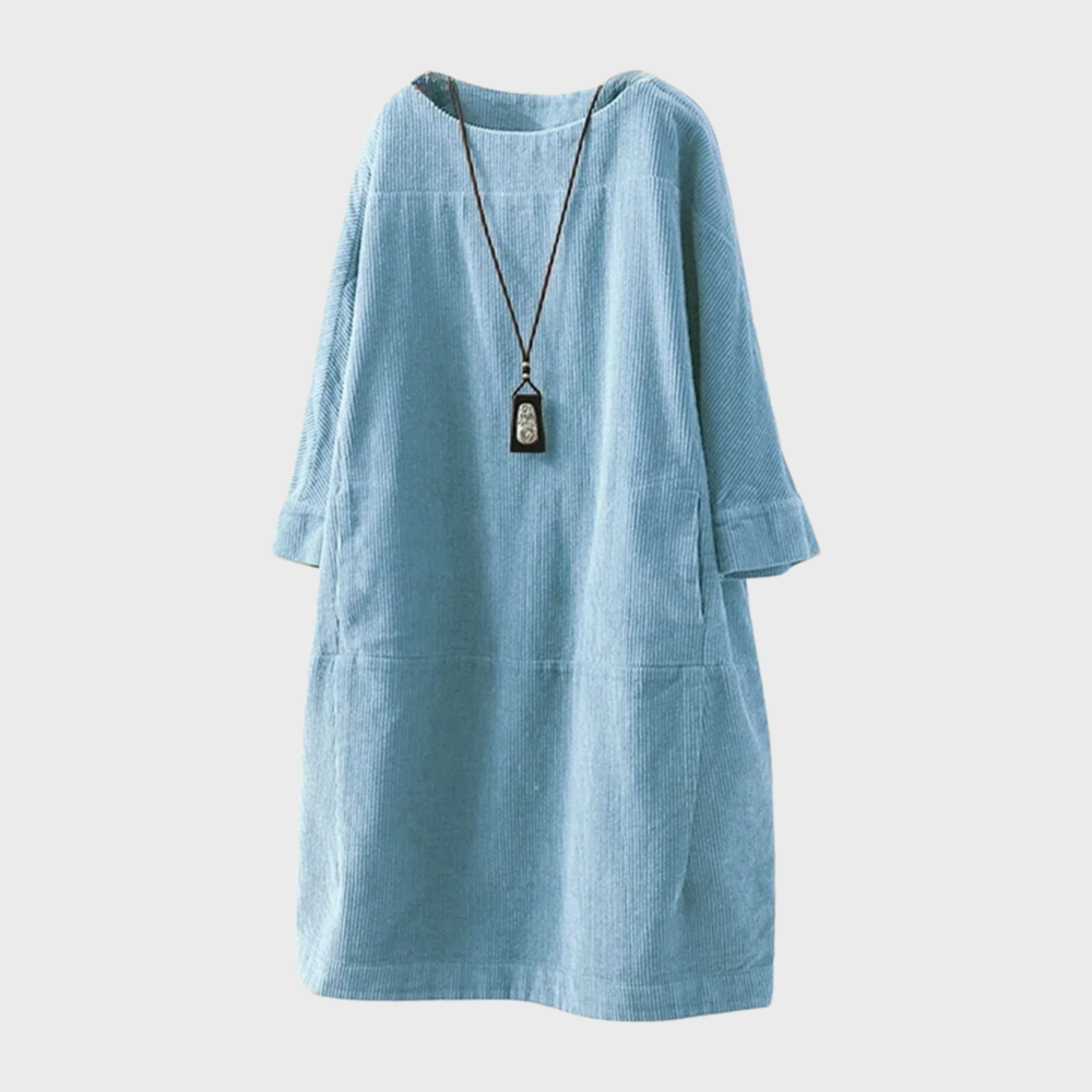 Blauwe corduroy damesjurk met lange mouwen en ronde hals, inclusief lange ketting. Stijlvolle casual outfit voor dames.
