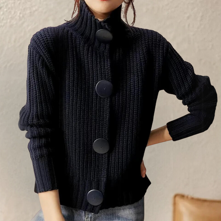 Donkerblauwe gebreide damestrui met grote knopen, hoge kraag en lange mouwen. Modieuze herfst- en winterkleding, casual stijl.