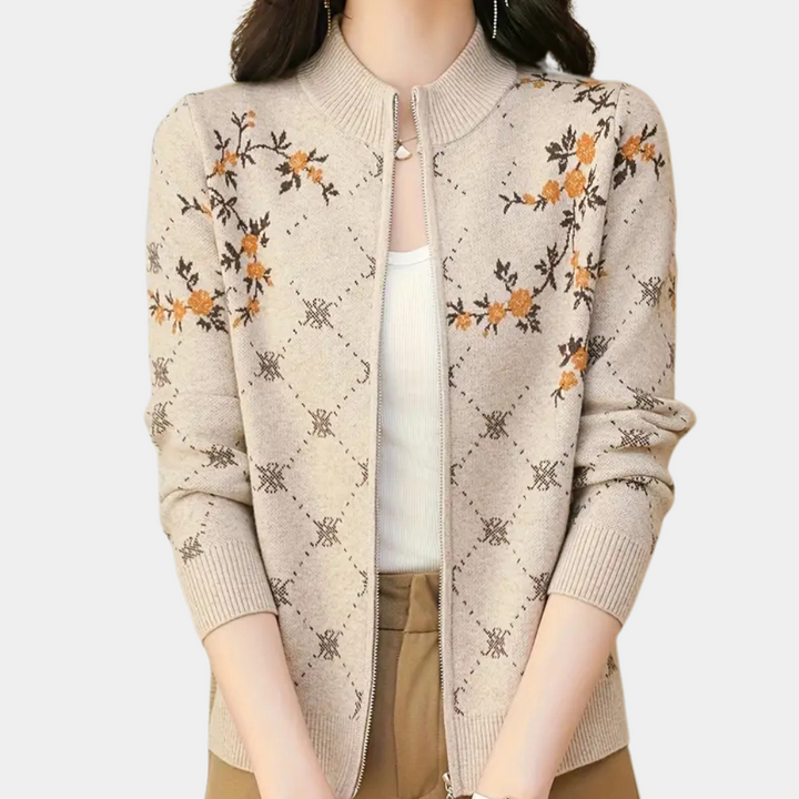 Vrouw draagt beige gebreid vest met bloemenpatroon, ritssluiting en opstaande kraag. Modieuze dameskleding, herfststijl, casual elegantie.