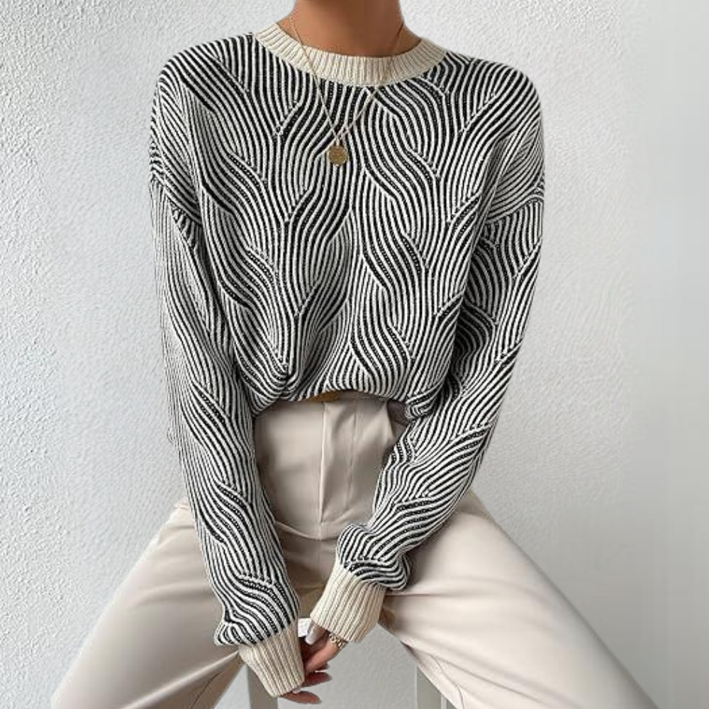 Stijlvolle zwart-witte trui met golvend patroon, gedragen door model. Perfect voor modieuze herfst- en winteroutfits. Comfortabel en trendy design.