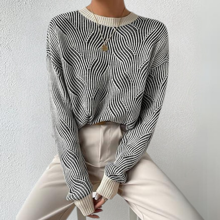 Stijlvolle zwart-witte trui met golvend patroon, gedragen door model. Perfect voor modieuze herfst- en winteroutfits. Comfortabel en trendy design.
