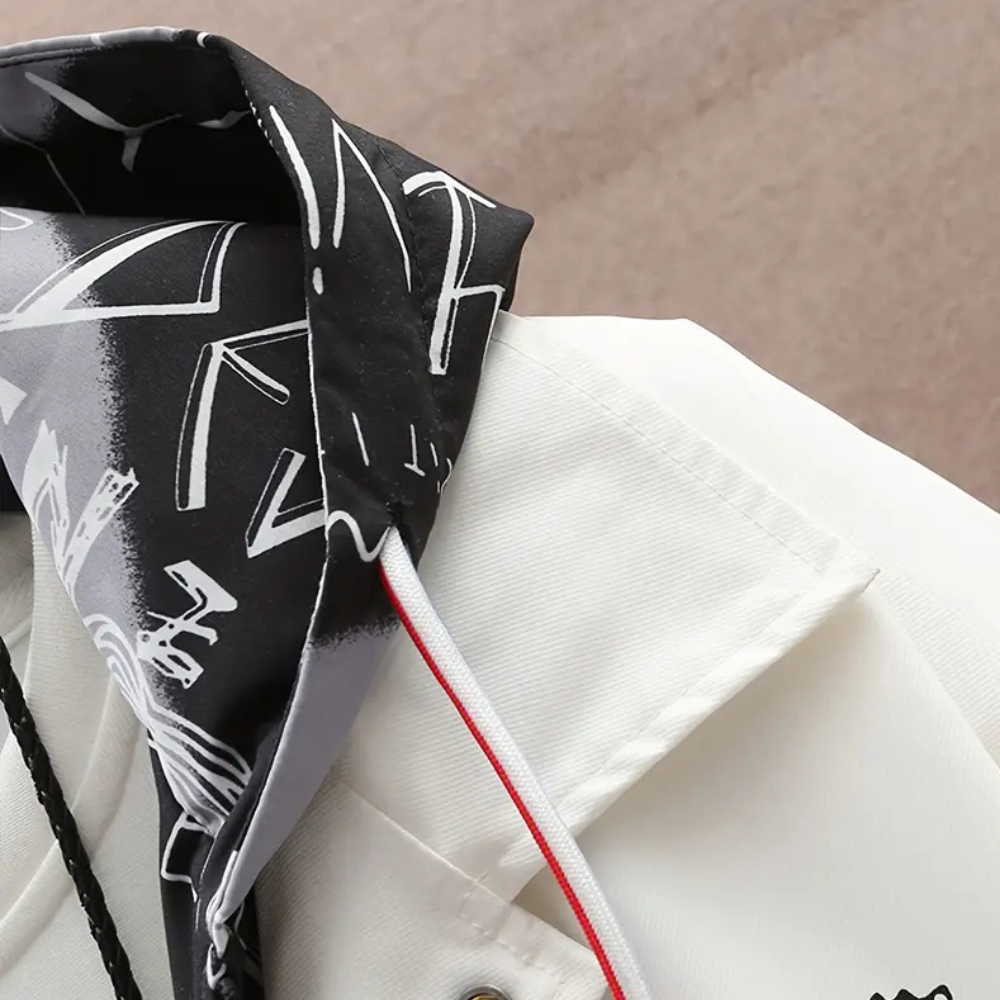 Witte jas met zwart-witte grafische capuchon, close-up. Modieuze streetwear, unisex design, hoogwaardige stof, trendy kledingstijl.