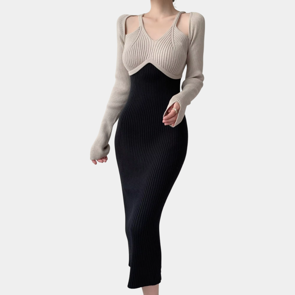 Vrouw in stijlvolle, tweekleurige gebreide jurk met lange mouwen en unieke snit. Modieuze dameskleding, elegant en trendy design.