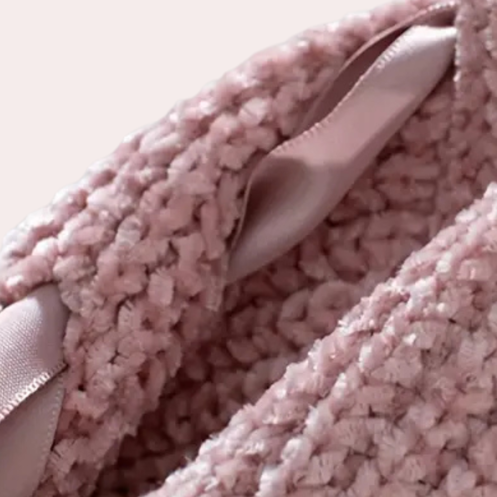 Roze gebreide deken met satijnen lint, zachte textuur, close-up. Perfect voor babykamer, interieurdecoratie, warme en comfortabele uitstraling.