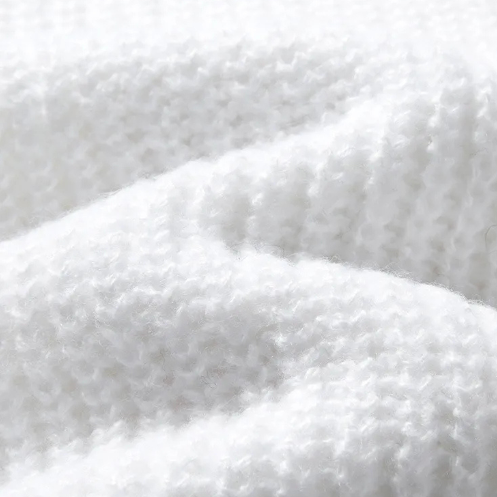 Witte gebreide stof close-up, zachte textuur, ideaal voor winterkleding en breiprojecten. Hoogwaardige wol, comfortabel en warm.