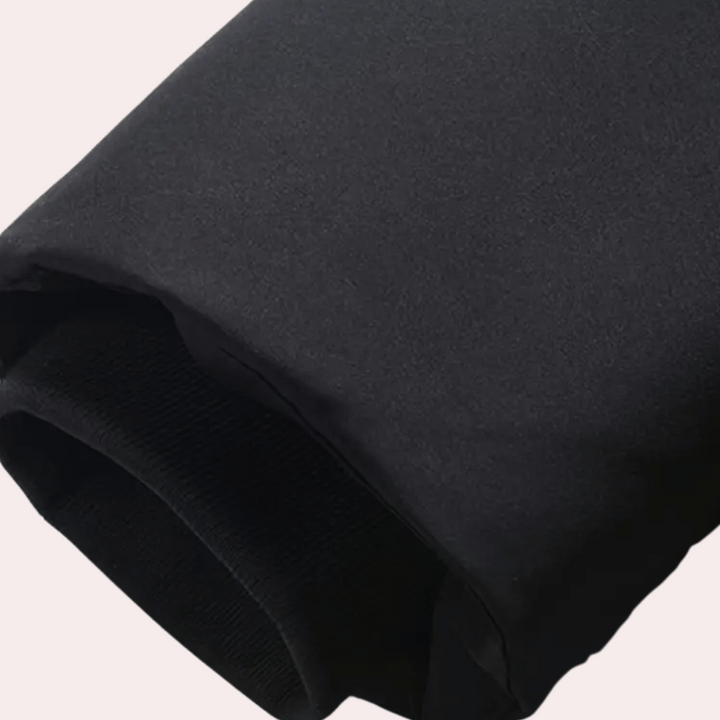 Zwarte winterjas mouw, close-up. Hoogwaardige stof, warme voering. Perfect voor koude seizoenen. Stijlvolle en functionele winterkleding.