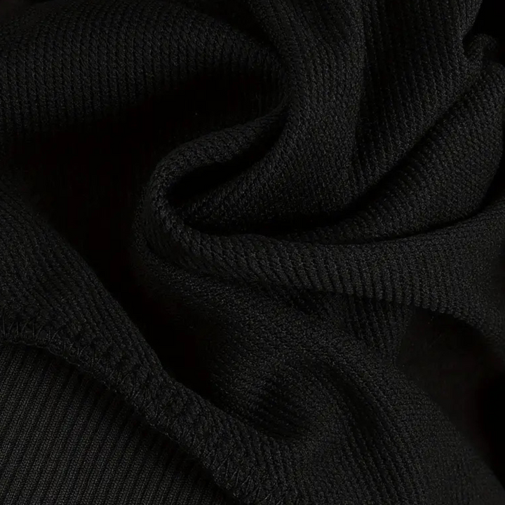 Zwarte ribgebreide stof close-up, textuur van katoenmix, geschikt voor kleding en modeontwerp. Hoogwaardige, duurzame textielmaterialen.