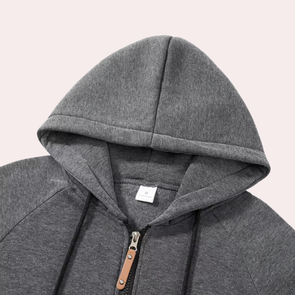 Grijze hoodie met capuchon, ritssluiting en leren trekkoord. Comfortabele katoenen stof, ideaal voor casual en sportieve outfits. Unisex design.