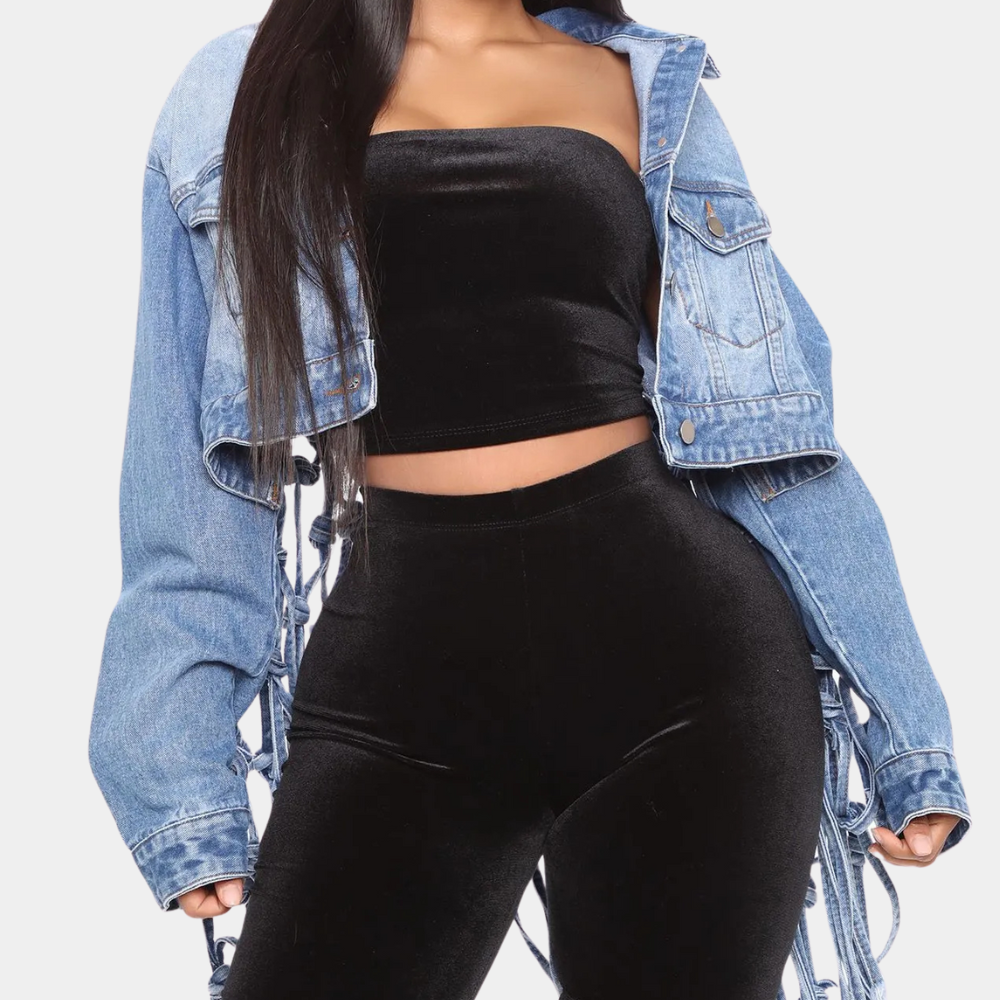 Vrouw in zwarte fluwelen crop top en broek, met blauwe spijkerjas. Modieuze dameskleding, trendy outfit, casual stijl.