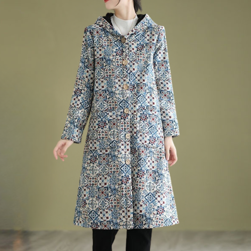 Vrouw draagt lange, blauwe vintage jas met bloemenpatroon en knopen, stijlvolle wintermode, trendy dameskleding, elegante buitenkleding.