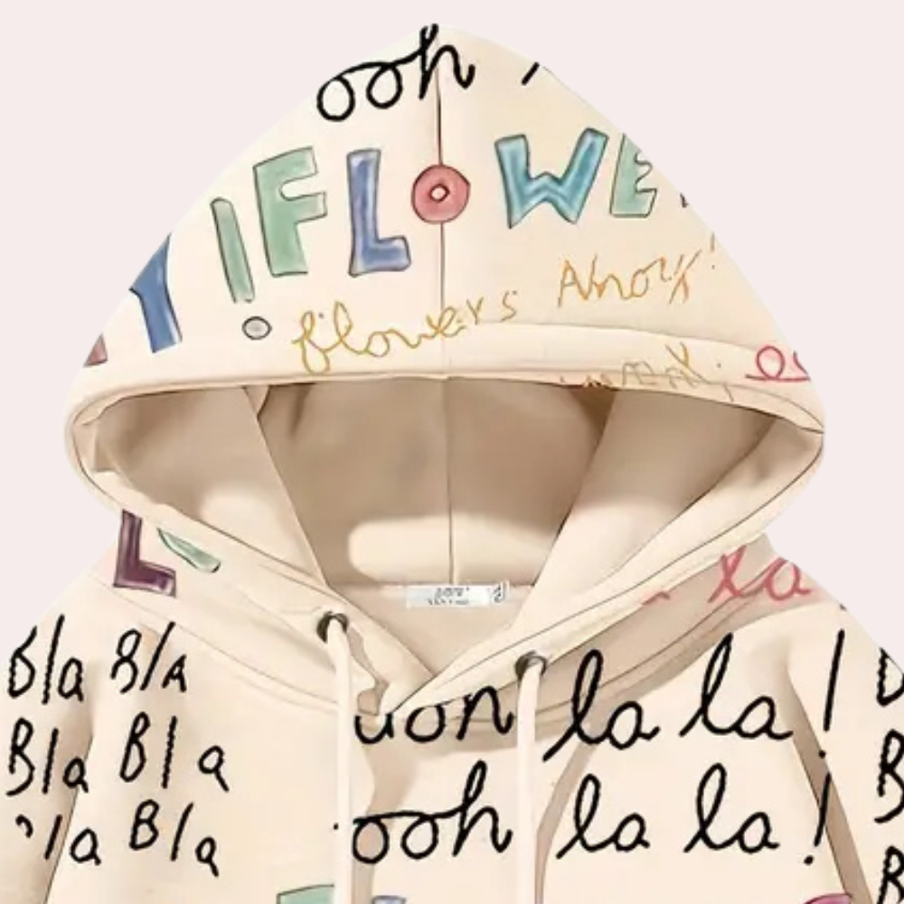 Beige hoodie met kleurrijke, handgeschreven teksten en patronen, zoals "flowers" en "bla bla", op een lichte achtergrond. Trendy streetwear mode.