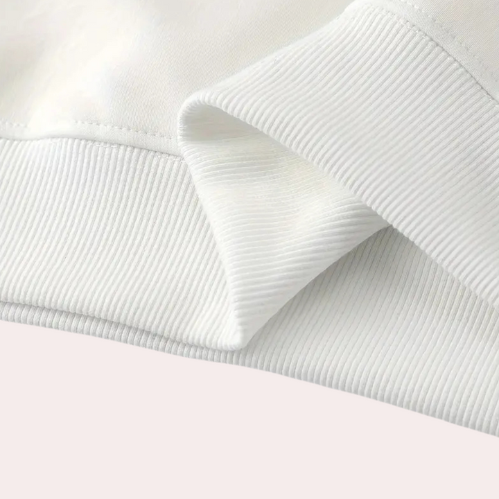 Witte katoenen trui close-up, geribbelde zoom en mouw, minimalistisch design, comfortabele kleding, mode, textuur detail, casual stijl.